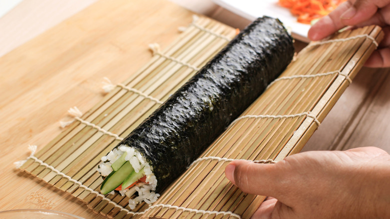 rolling sushi in bamboo mat