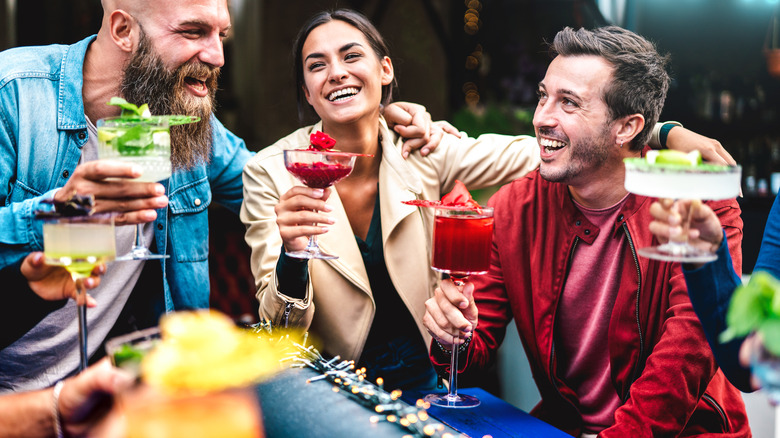 Group of people talking and laughing with cocktails