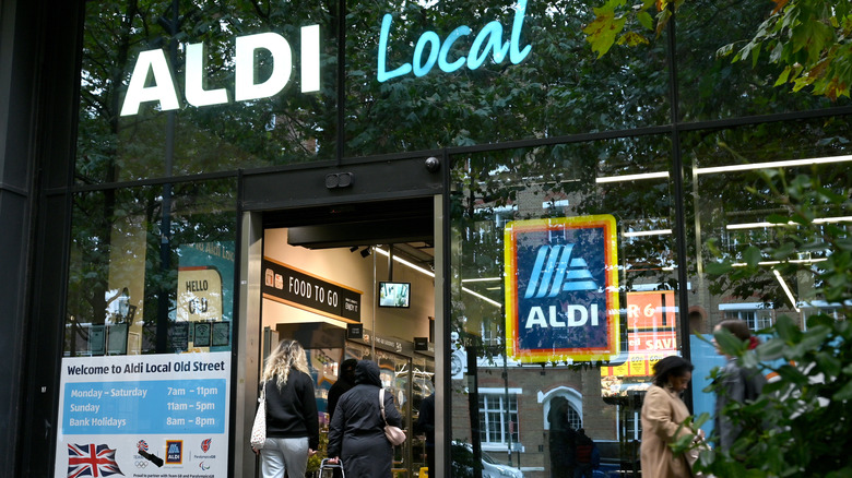 Front of an Aldi with large windows reflecting a London street