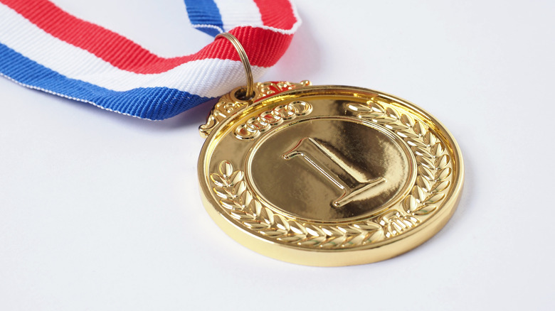 Gold medal with engraved with number one against white background