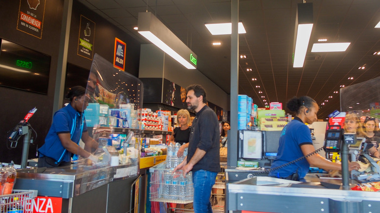 Two lines of customers being rung up at Aldi