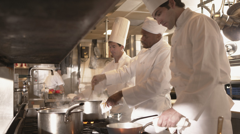 Restaurant kitchen chefs over stoves