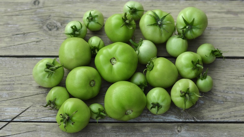 Green tomatoes on wooden background