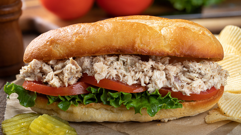 A crab meat sub sandwich with lettuce, tomatoes, and pickles