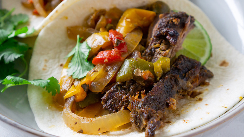 4-Ingredient Slow Cooker Fajitas on tortilla with lime and herbs