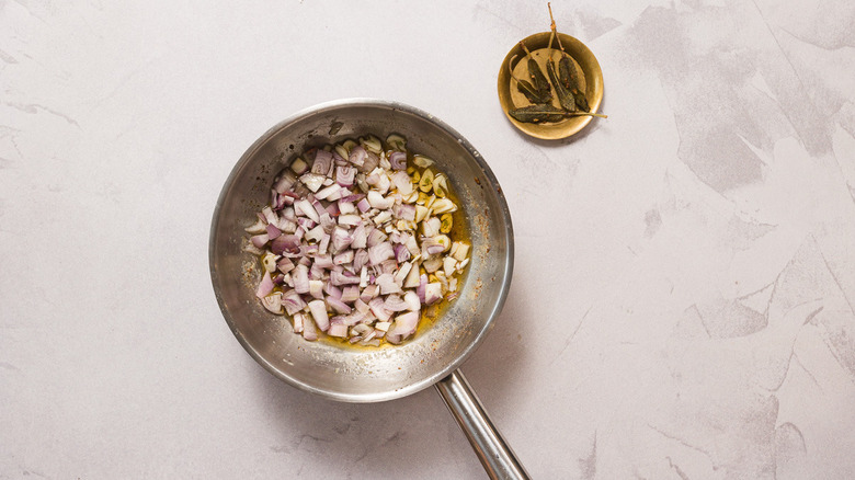 Onions in pan beside fried sage