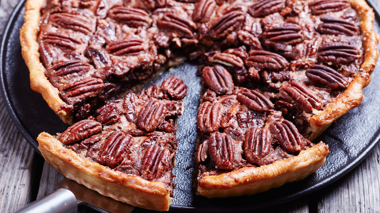 Whole pecan pie with a couple slices cut out