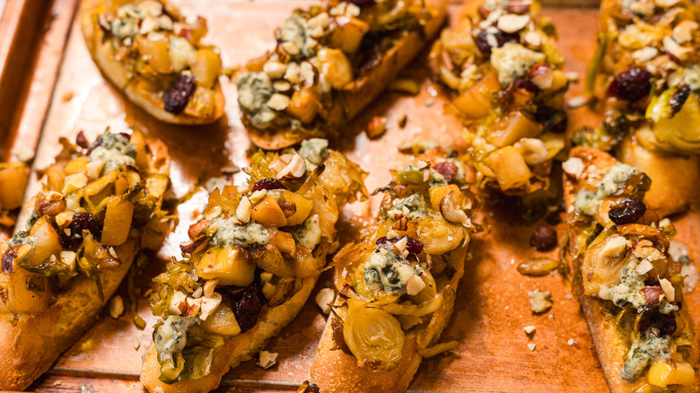 Slices of bruschetta with Brussels sprouts, pears and gorgonzola cheese on a baking sheet