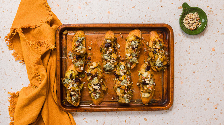 Slices of bruschetta with Brussels sprouts, pears and gorgonzola cheese on a baking sheet