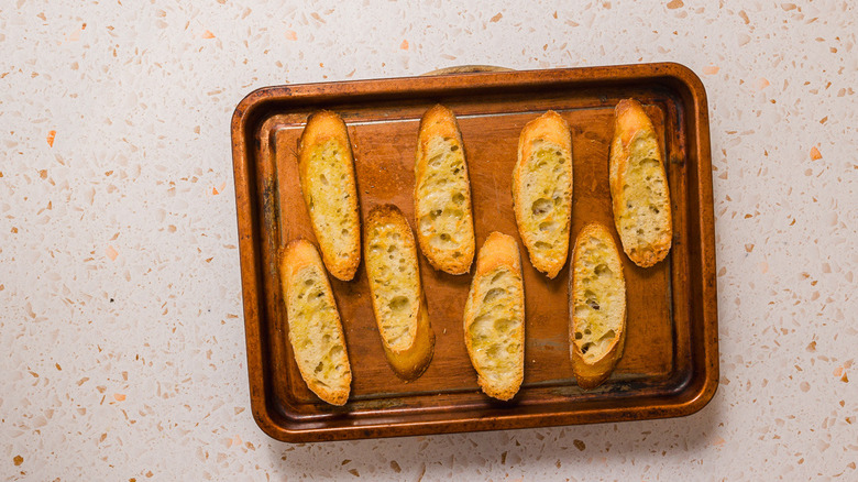 Toasted baguette slices on baking sheet