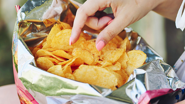 eating from a family or party size bag of potato chips