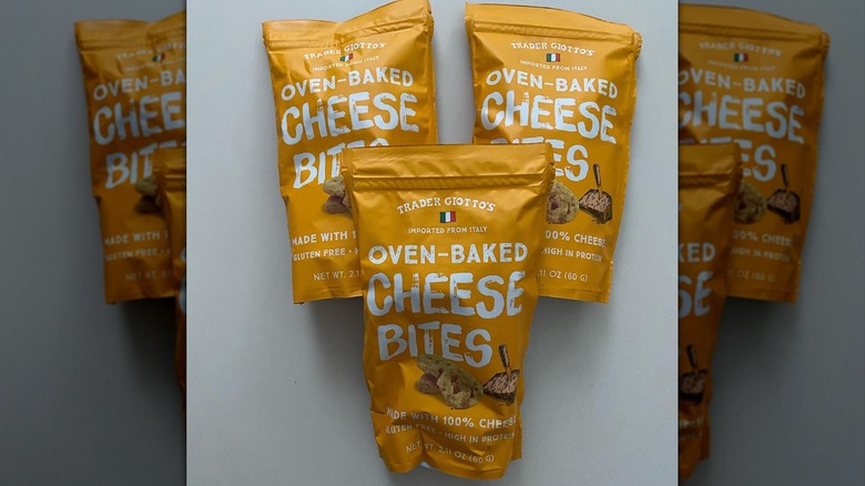 three packages of Trader Joe's Oven-Baked Cheese Bites displayed on grey background