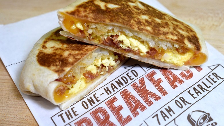 Breakfast Crunchwrap from Taco Bell cut in half on paper menu