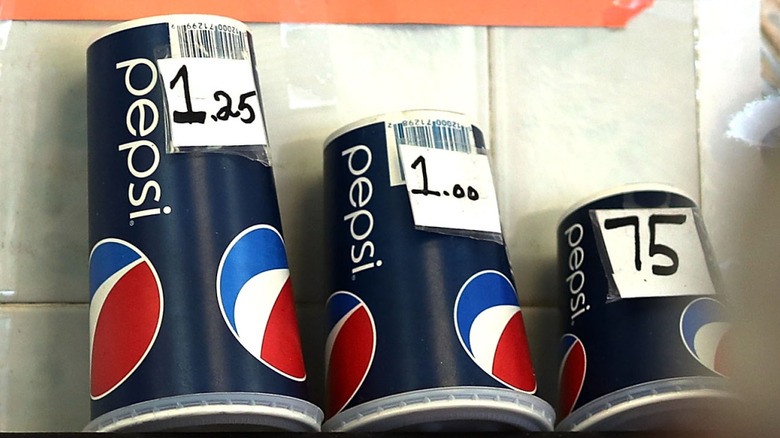 Three different sized, Pepsi branded beverage cups sitting upside down and labeled 75 cents,$1, and $1.25