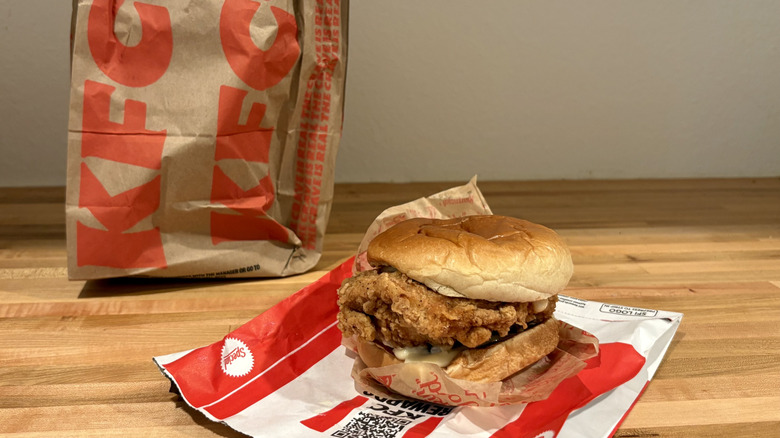 KFC chicken sandwich with mayo next to its paper bag