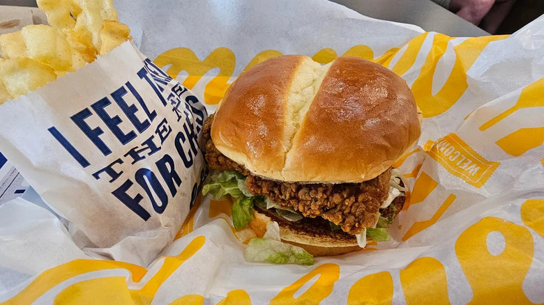 Culver's chicken sandwich on branded paper wrapping next to a bag of fries
