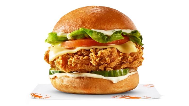 Crispy chicken sandwich with cheese, tomato, lettuce, pickles, and mayo