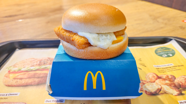 McDonald's Filet-O-Fish sitting on a container on a tray at table