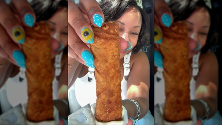 Person dipping a Jack in the Box jumbo egg roll into a tub of creamy dip