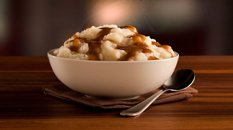 Bowl of KFC mashed potatoes with gravy next to a spoon