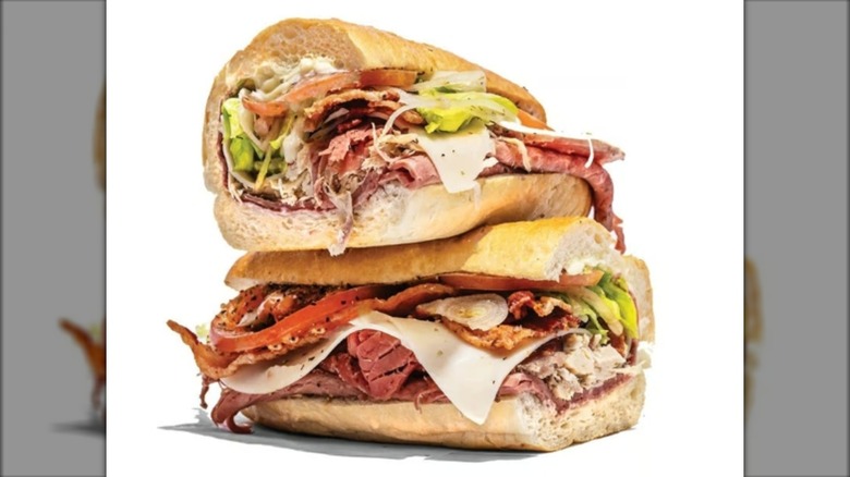 Stacked club sandwich with beef, turkey, cheese, tomato, and lettuce