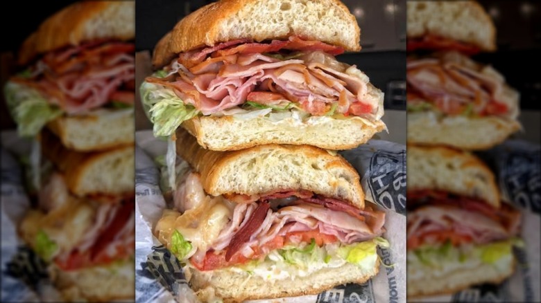 Sub sandwich with cheese, turkey, ham, bacon, lettuce, and tomato