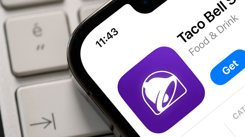 Phone with a Taco Bell app sitting on a keyboard