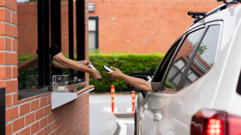 Customer in a drive-thru paying for an order