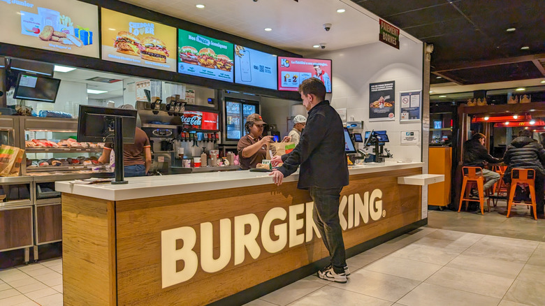 Man standing at a counter at Burger King to order