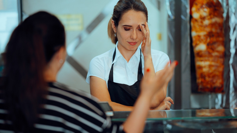 Customer yelling at an employee who's standing behind a counter