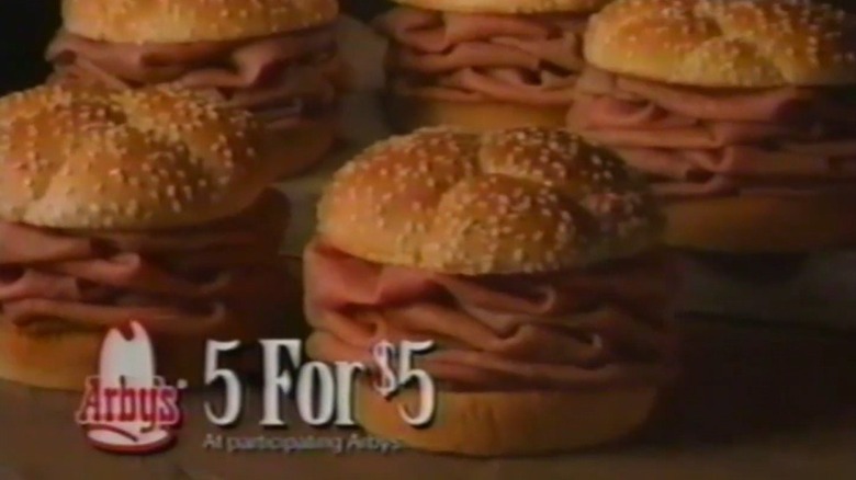 Five Arby's roast beef sandwiches piled high with shaved roast beef on sesame seed buns with the logo for Arby's next to the text 5 for $5
