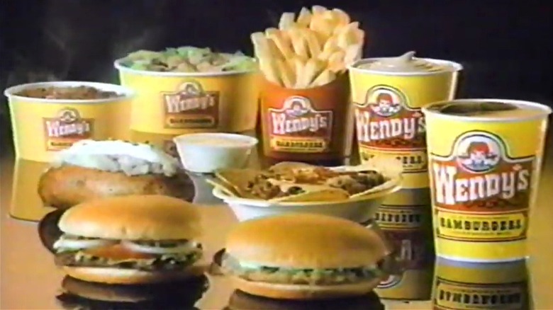 A display of nine items from Wendy's in the old style yellow packaging in a vintage ad