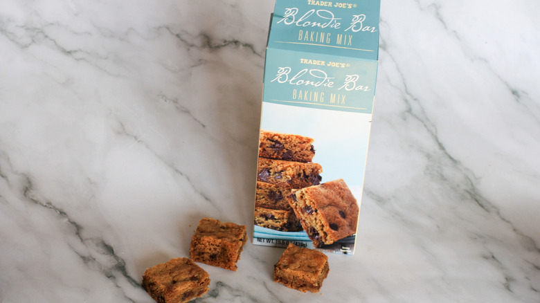 A box of Blondie Bar Baking Mix, next to three baked blondie bar squares