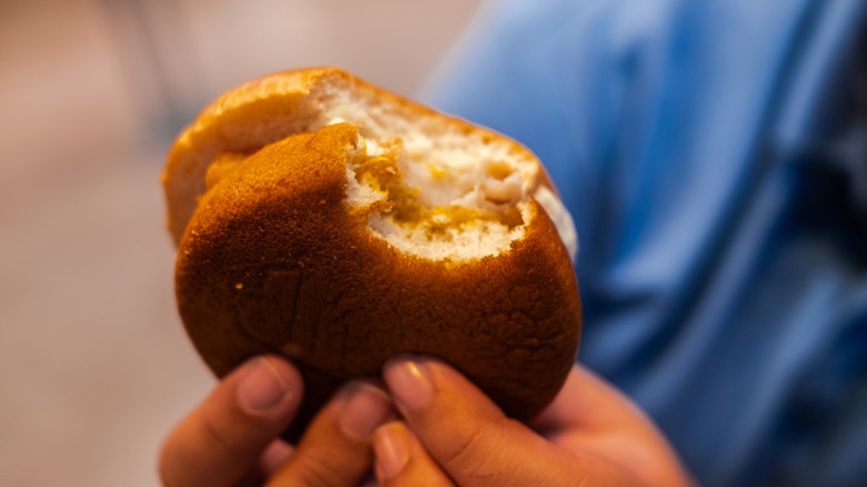 A person holds a filet-o-fish with a bite taken