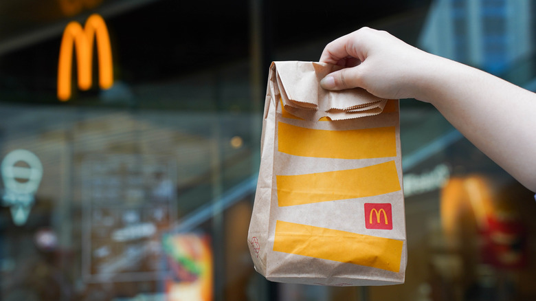 Customer holding a McDonald's carryout bag