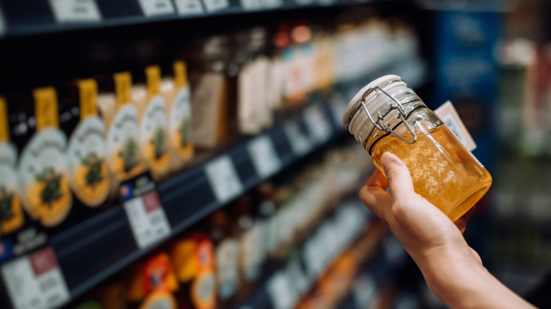 A shopper holds a jar of honey