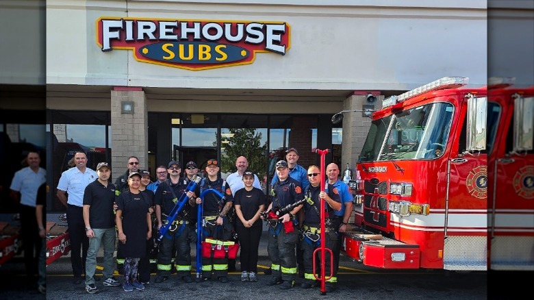 Firefighters holding new equipment outside Firehouse Subs.
