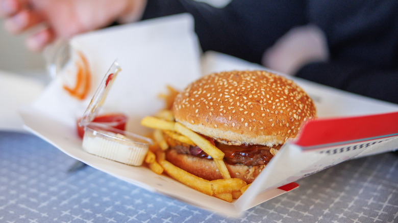 A chef pressing hamburger patties on a grill
