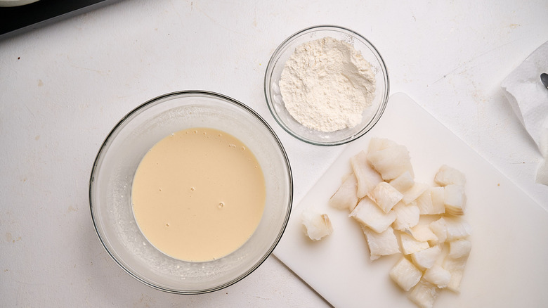 flour in a bowl next to beer batter on a table