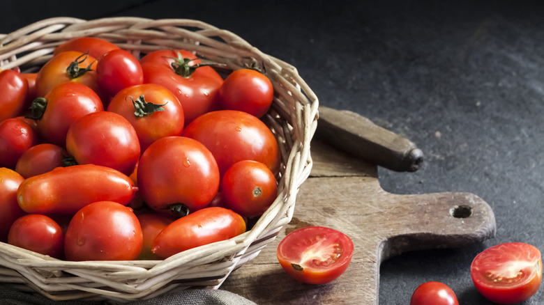 Tomatoes stored in open basket on wood slab