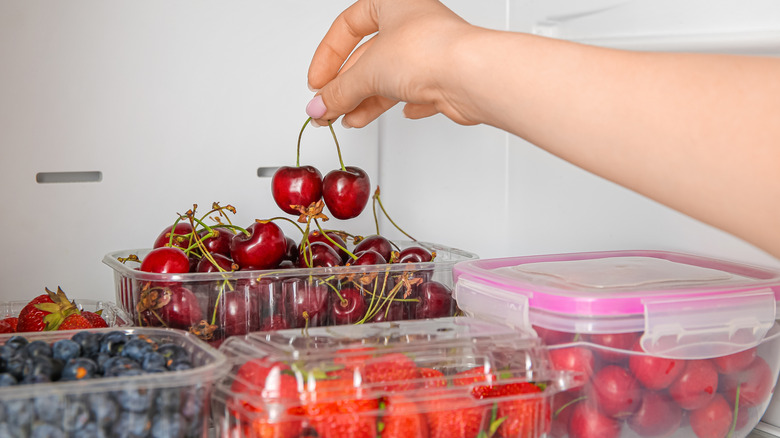 Berries in various fridge containers in refrigerator