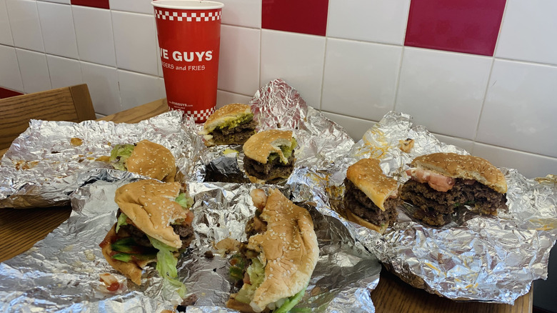 half-eaten "popular picks" burgers from Five Guys with drink