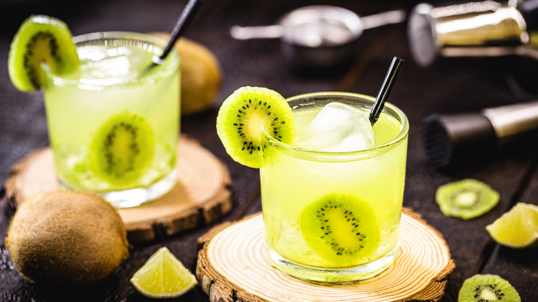 Two glasses of kiwi juice with lime wedges