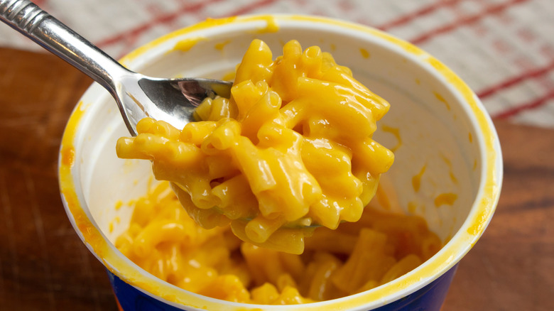 spoon with mac and cheese from a packaged cup