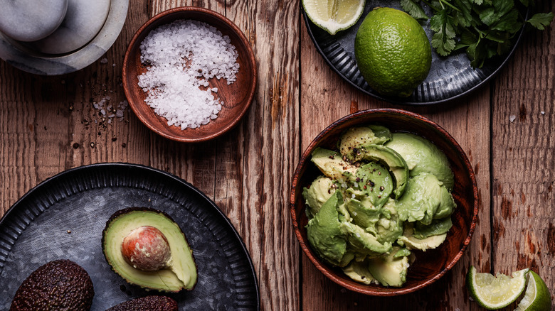 avocado bowl, salt bowl, lime, herbs on plate