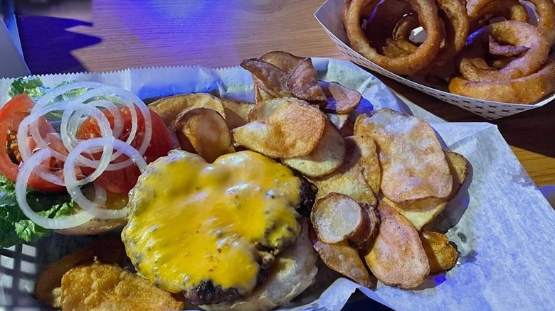 Cheeseburger and housemade chips plus onion rings from Gator Cove