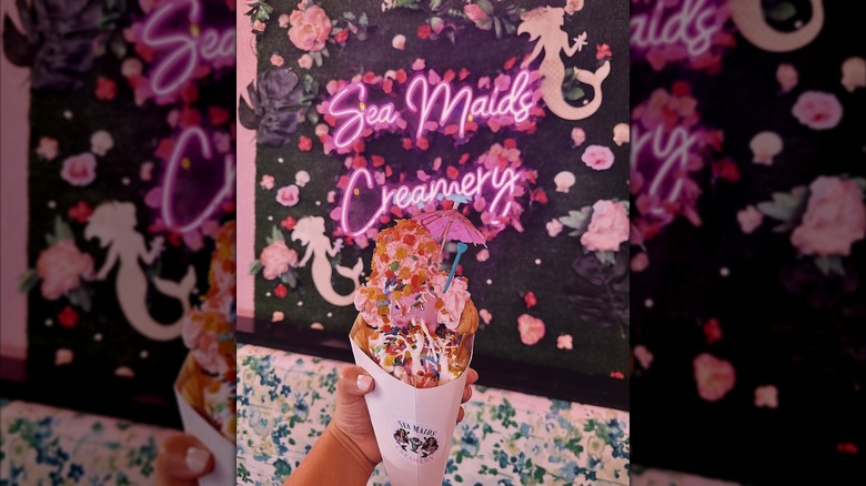 Ice cream with sprinkles against a neon sign