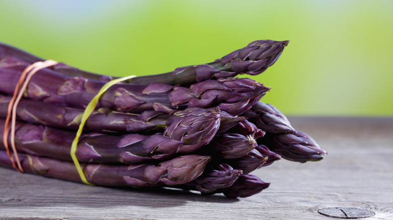 Purple asparagus bunch on wood