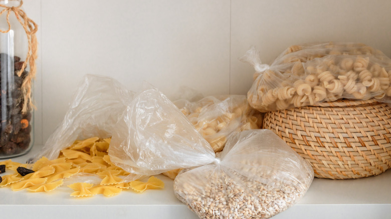 Messy pantry shelves with spilled packets of pasta