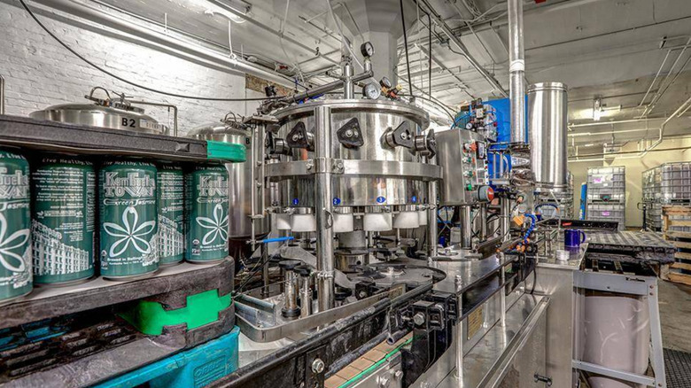 company-supplied image of its kombucha-brewing facility in Bellingham, WA, with cans of its "Green Jasmine" kombucha visible in the foreground and gleaming, clean machinery filling the rest of the room